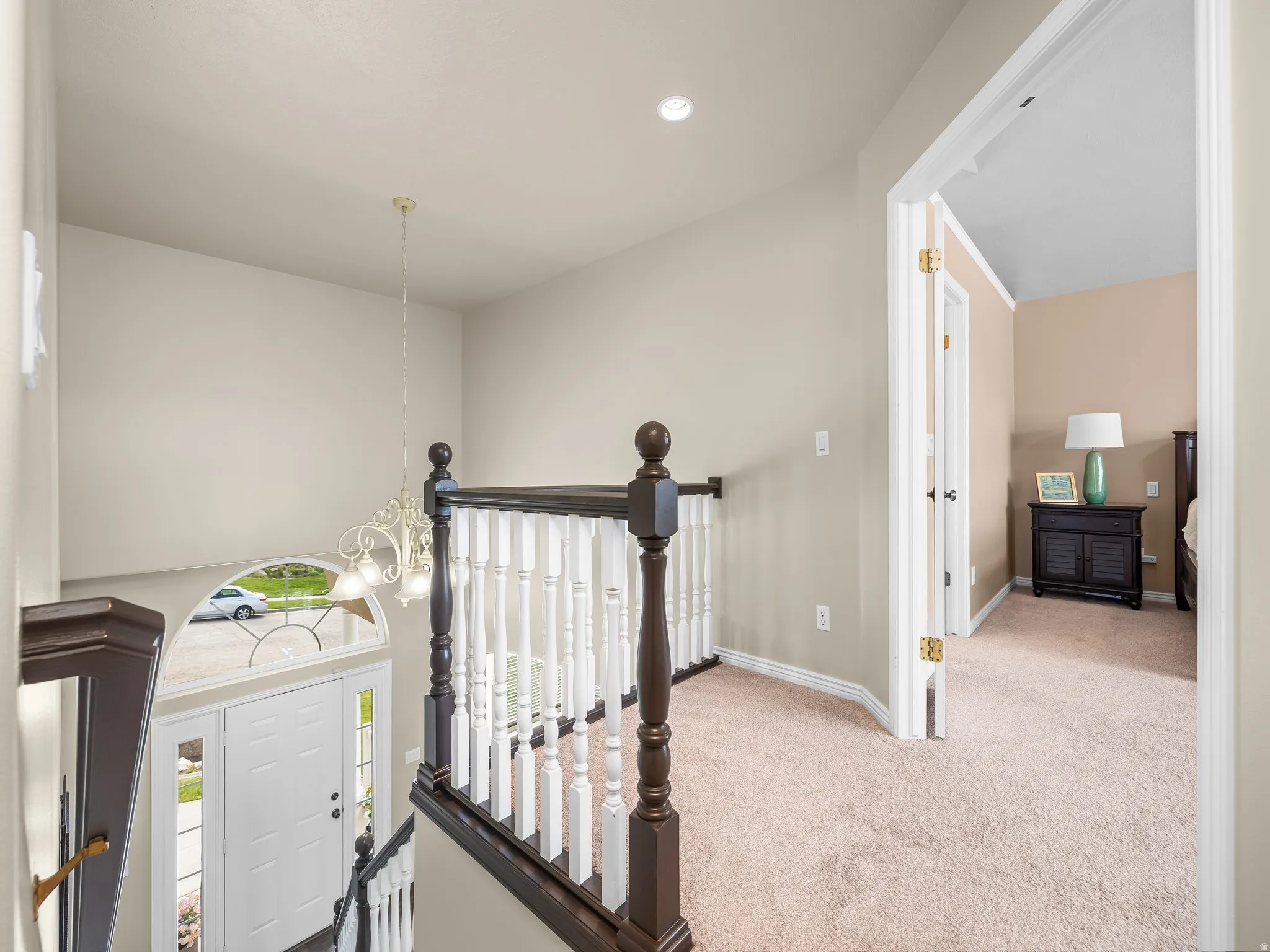 Split-level entryway featuring a white paneled door with sidelights and an arched transom window