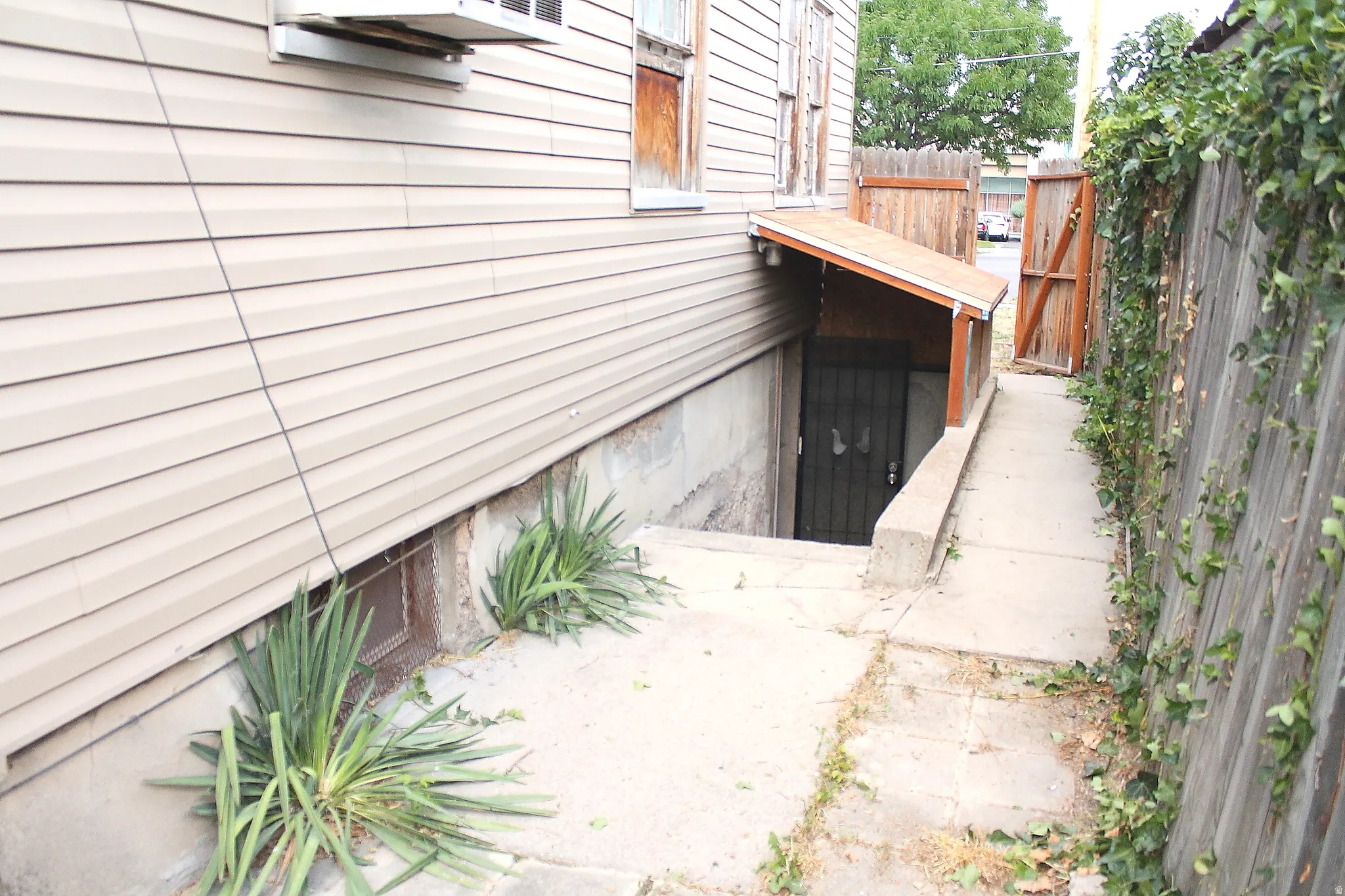 Exterior side access featuring concrete steps, a covered entryway, and a security screen door