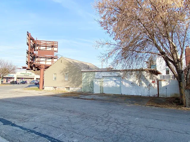 Commercial building featuring an exposed aggregate driveway, two garage doors, and a billboard structure