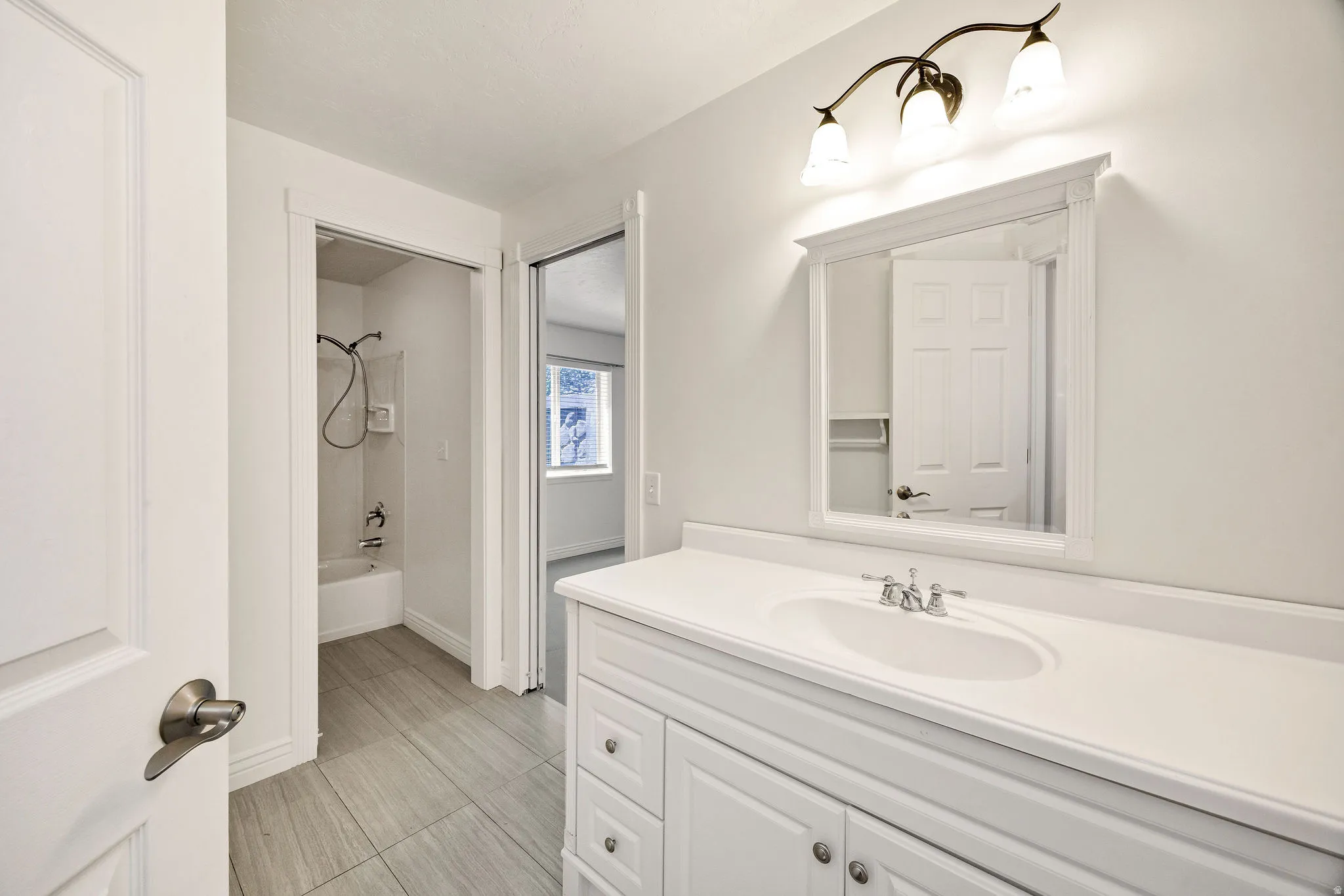 White vanity with integrated sink and chrome fixtures