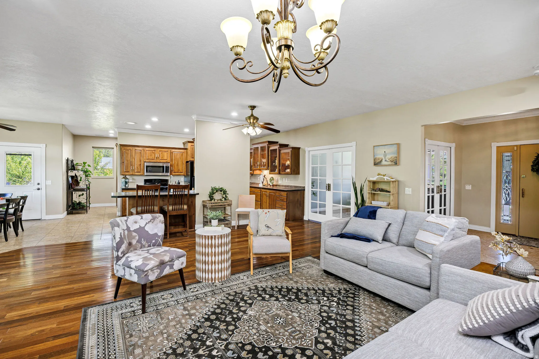 Spacious living area featuring wood-finish flooring, a decorative chandelier, and an open concept layout