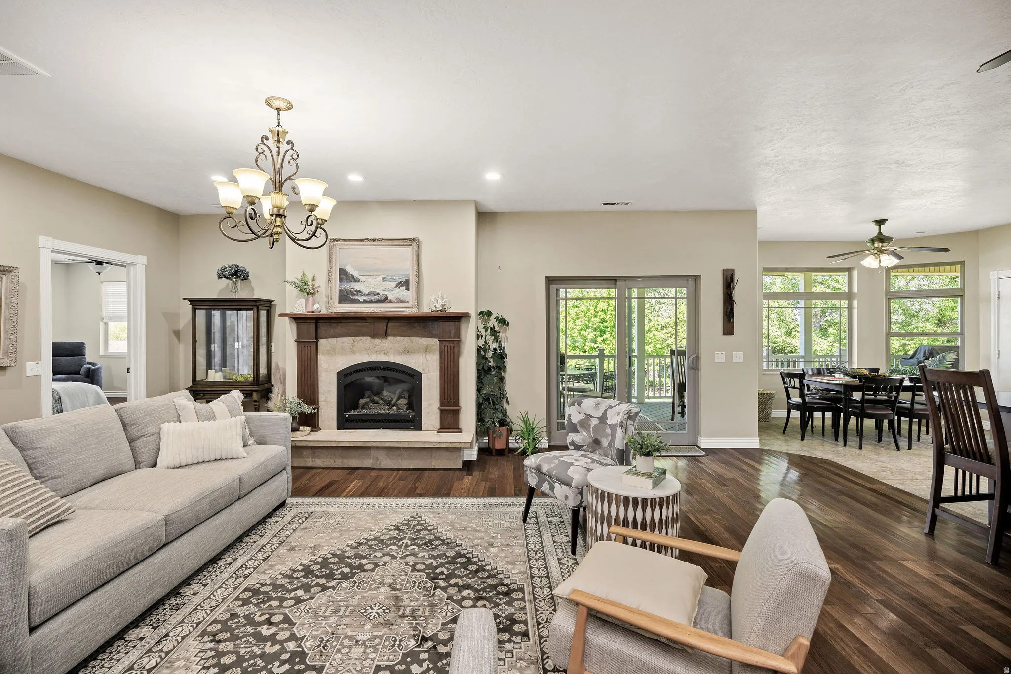Living area featuring a stone fireplace with a wood mantle, wood-finish flooring, and recessed lighting
