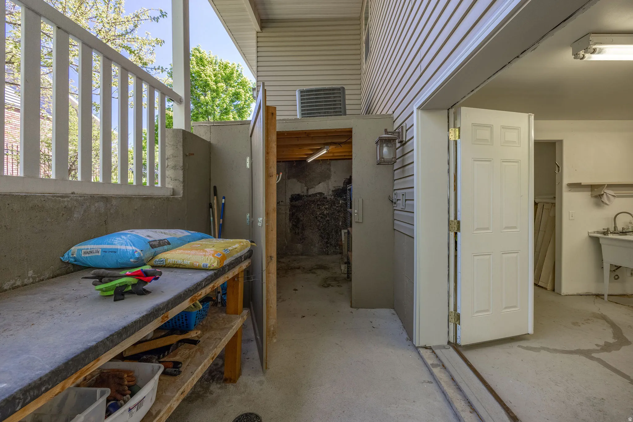 Outdoor work area featuring a concrete countertop with storage shelving below