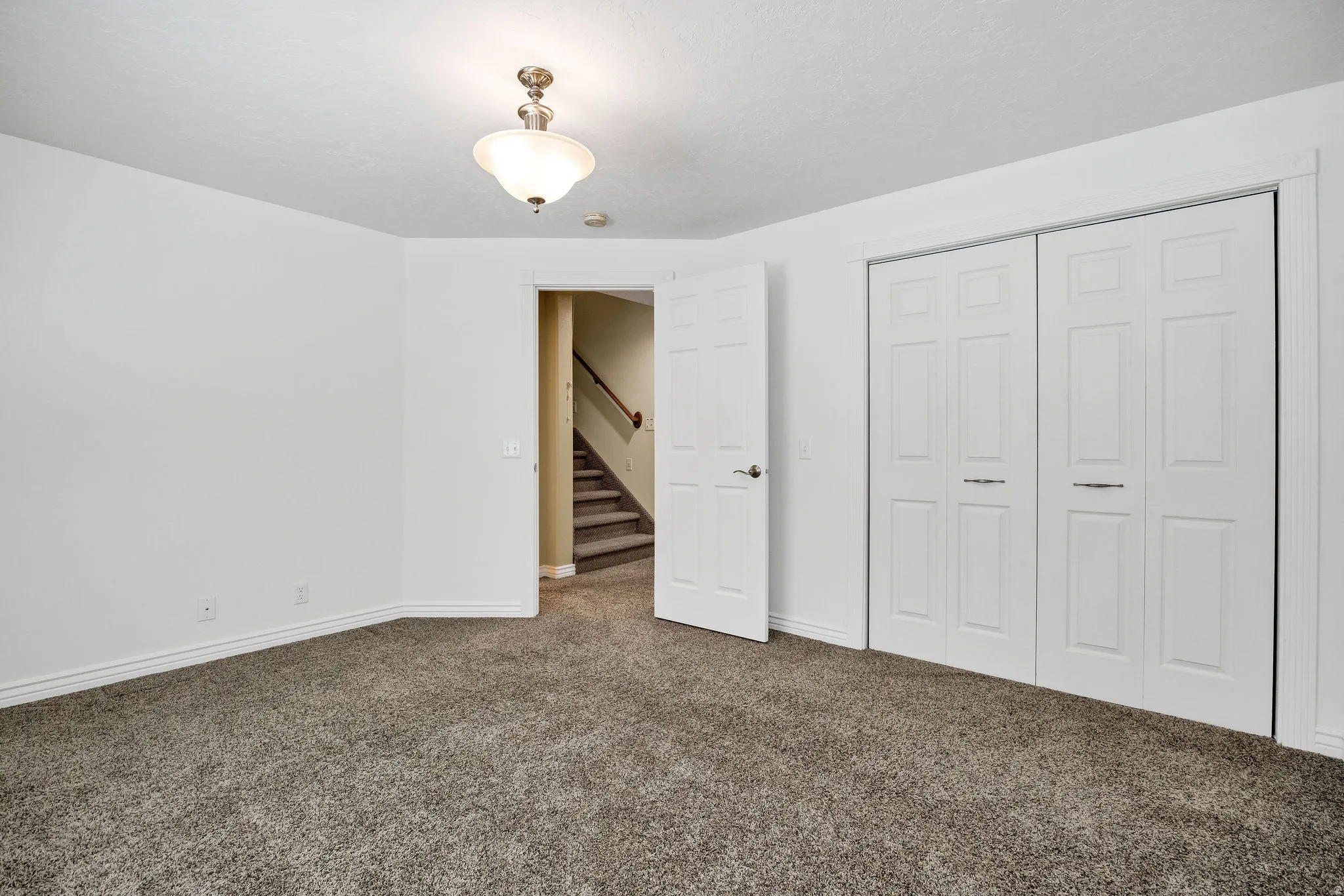 Carpeted room featuring white painted walls, white baseboards, and a semi-flush mount ceiling fixture
