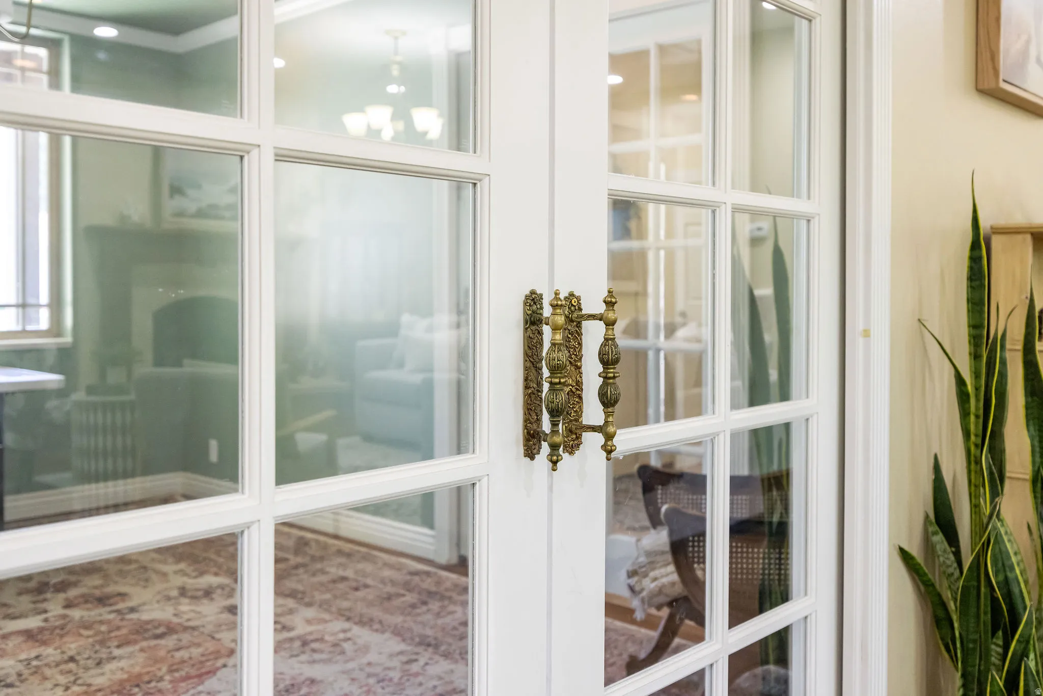 French doors with clear glass panes and an ornate brass handle