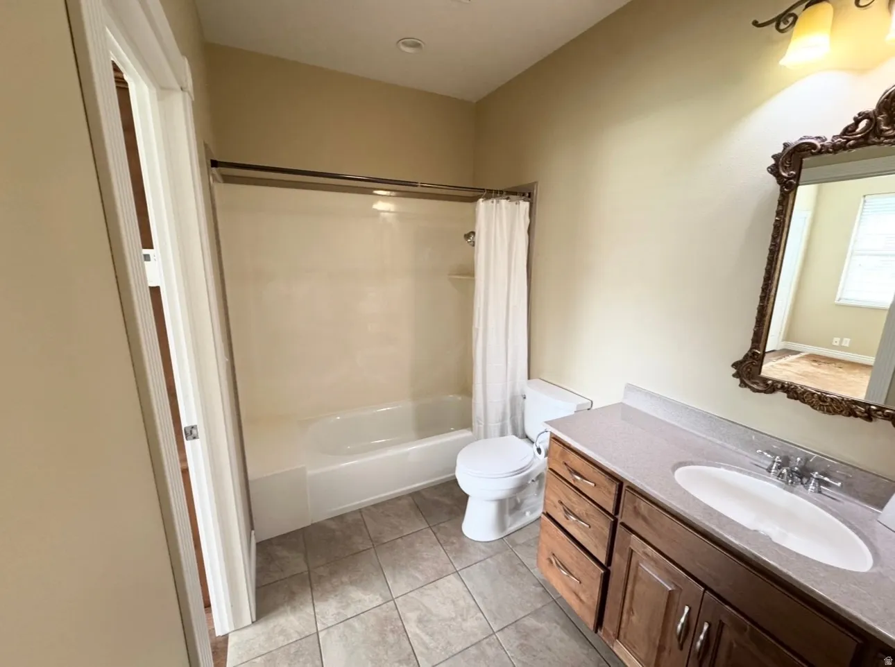 Bathroom featuring a single vanity with wood-finish cabinetry, a light-colored countertop, and a recessed sink