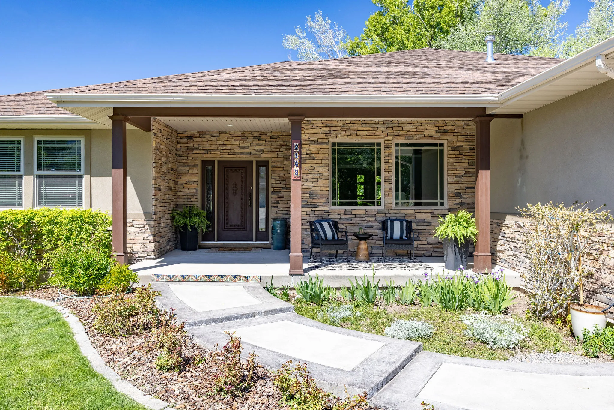 Stone veneer facade with a covered porch featuring dark wood columns
