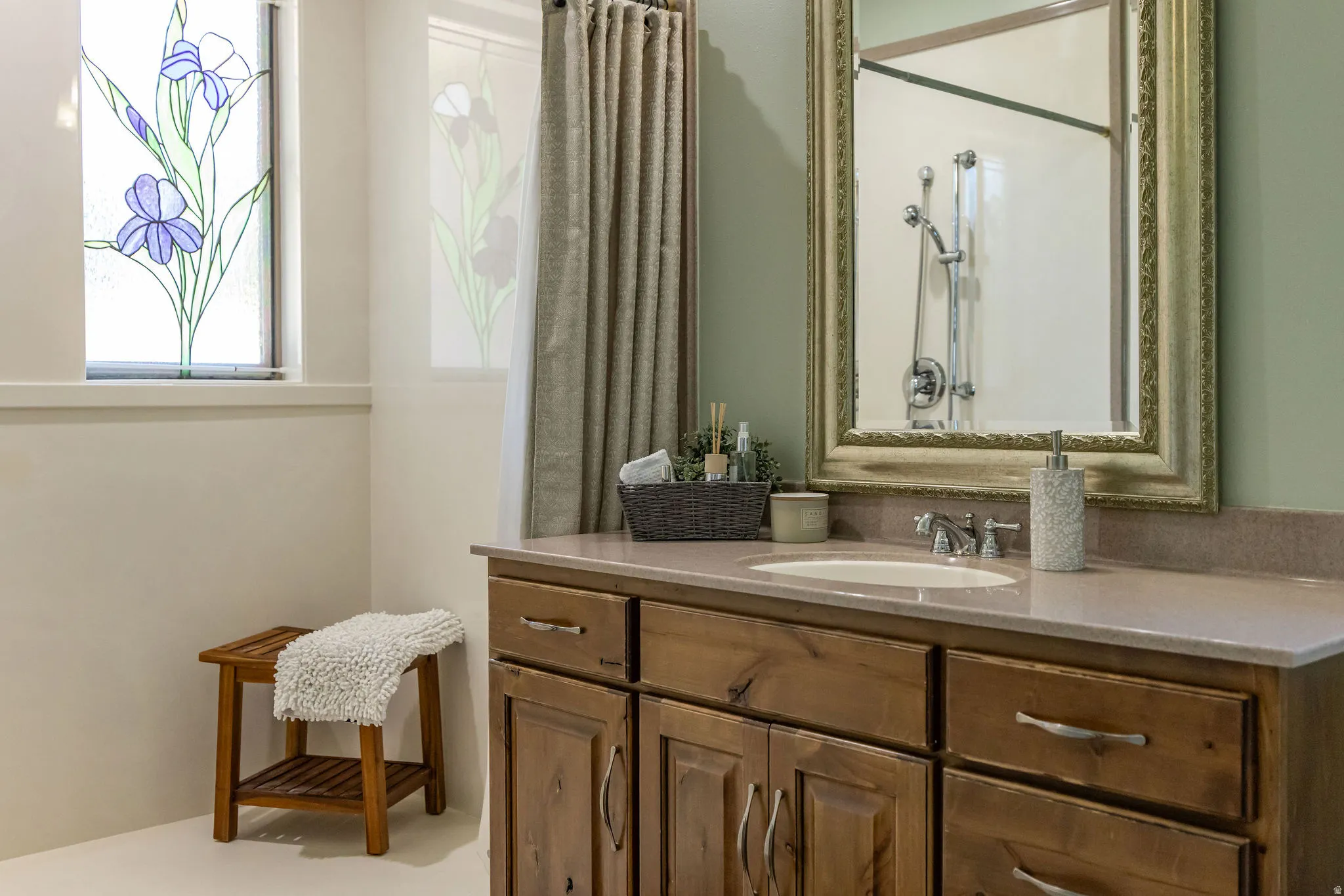 Bathroom vanity featuring an integrated sink, polished chrome faucet, and ample storage cabinetry