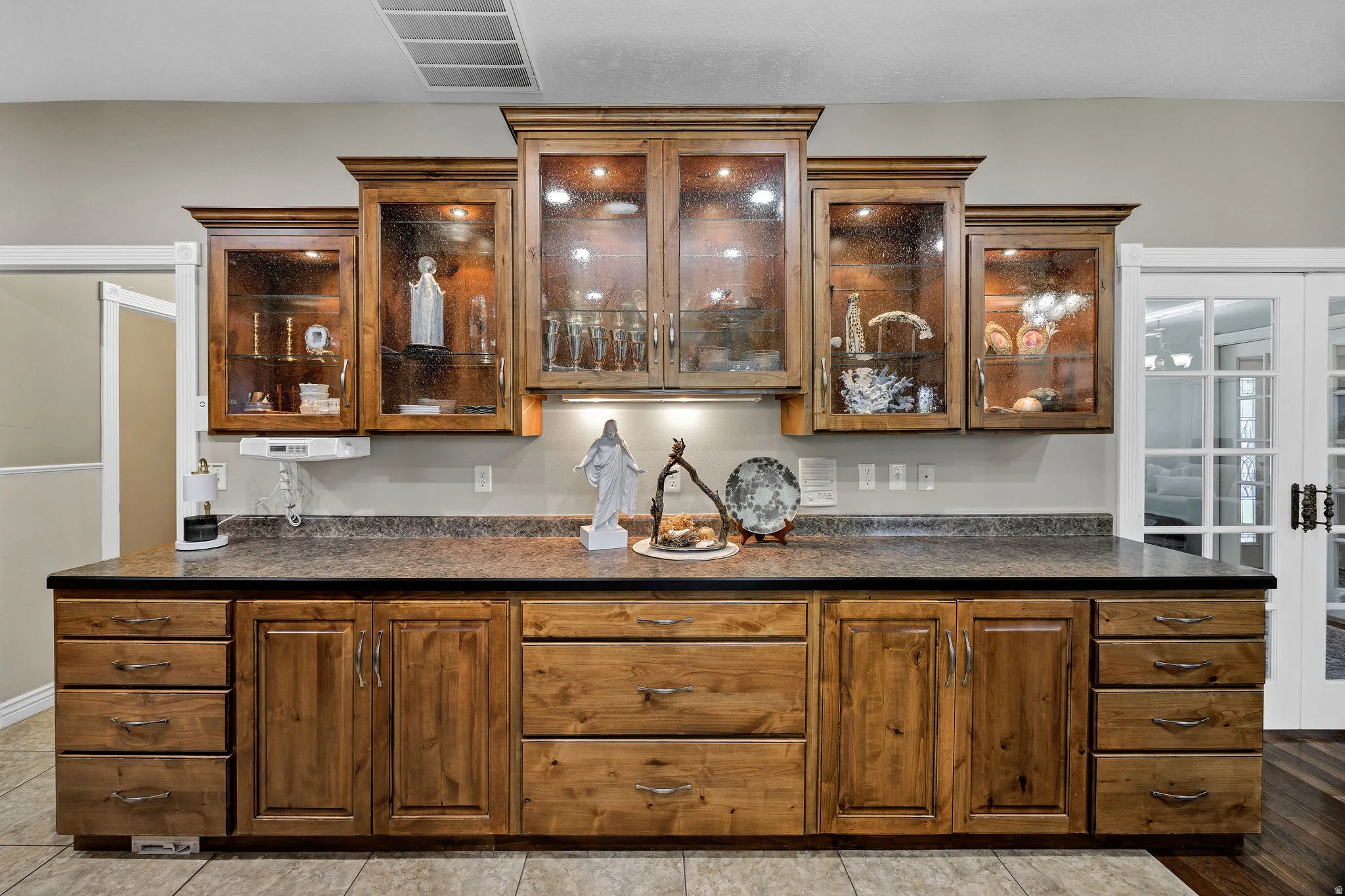 Custom wood cabinetry featuring glass-front uppers and under-cabinet lighting