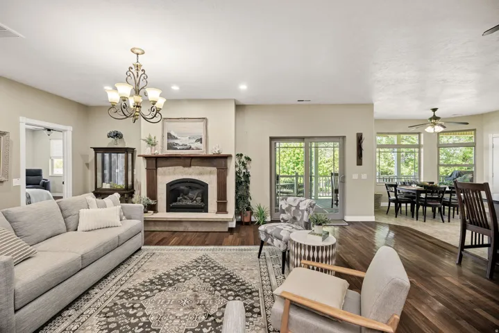 Living area featuring a stone fireplace with a wood mantle, wood-finish flooring, and recessed lighting