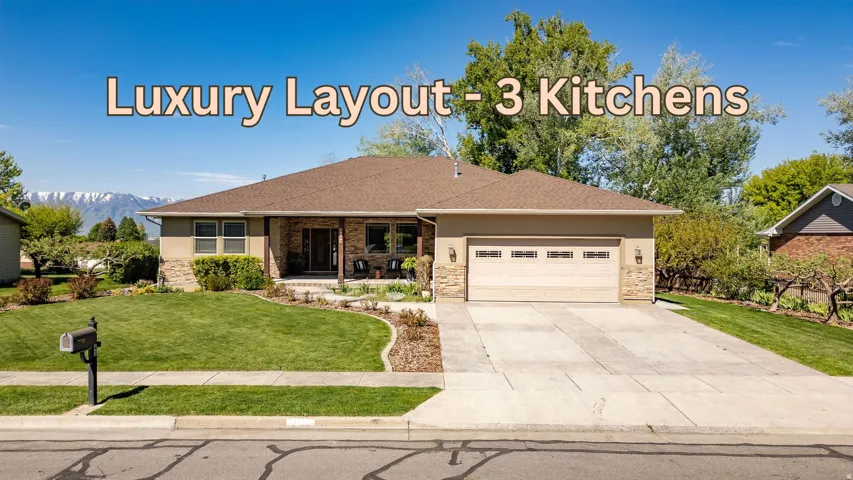 Stucco and stone exterior with a covered porch, attached garage, and concrete driveway