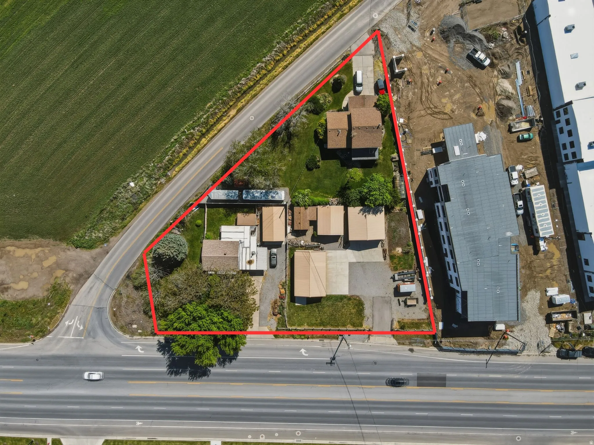Expansive lot featuring multiple structures, mature trees, and direct road frontage