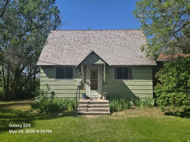 Single-story residence featuring green horizontal siding, a gabled roof, and a covered entry porch
