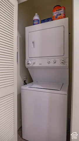 Stackable washer and dryer unit within a dedicated laundry closet featuring louvered bi-fold doors