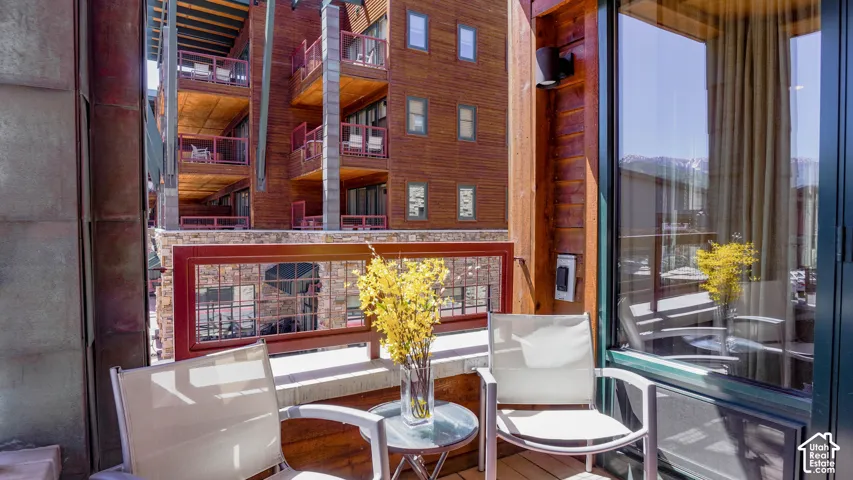 Private balcony featuring wood-finish flooring, a contemporary railing, and a windowed exterior wall