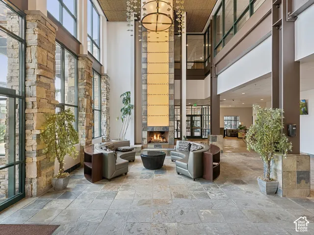 Two-story lobby featuring a stone-clad fireplace and expansive window walls