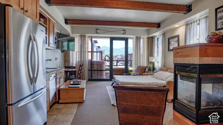 Open-concept living area with a full kitchen featuring stainless steel appliances and wood cabinetry