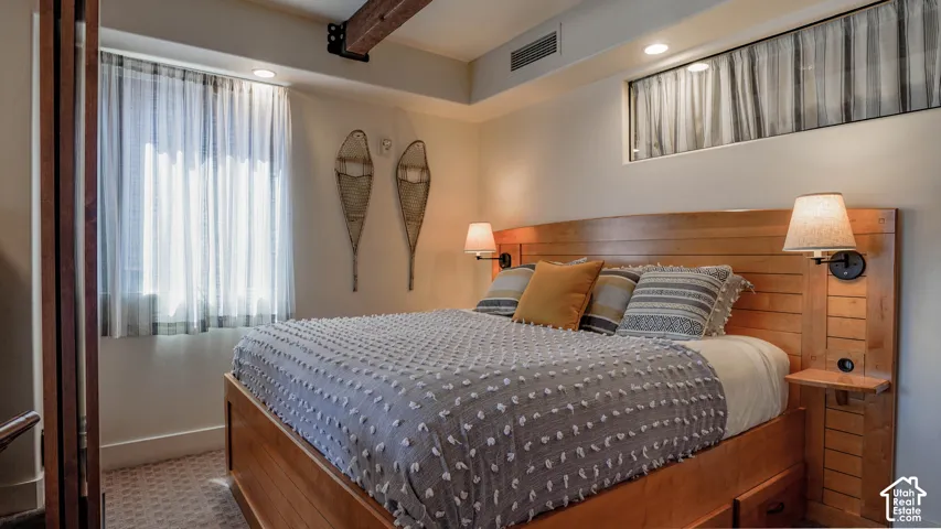 Warm wood bed frame with integrated side tables and wall-mounted sconces