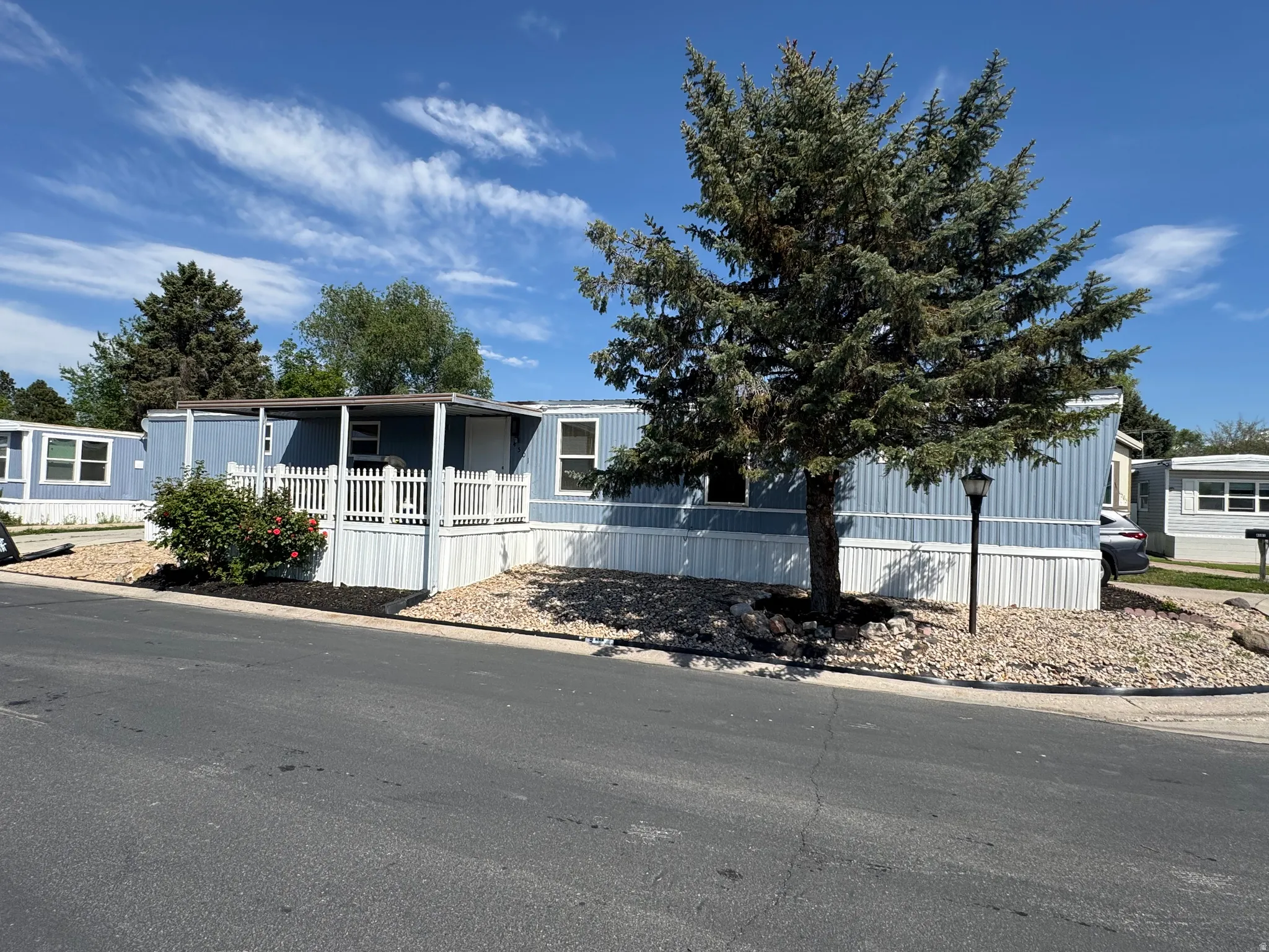 Light blue siding home with white trim, featuring a covered front porch with white picket railing