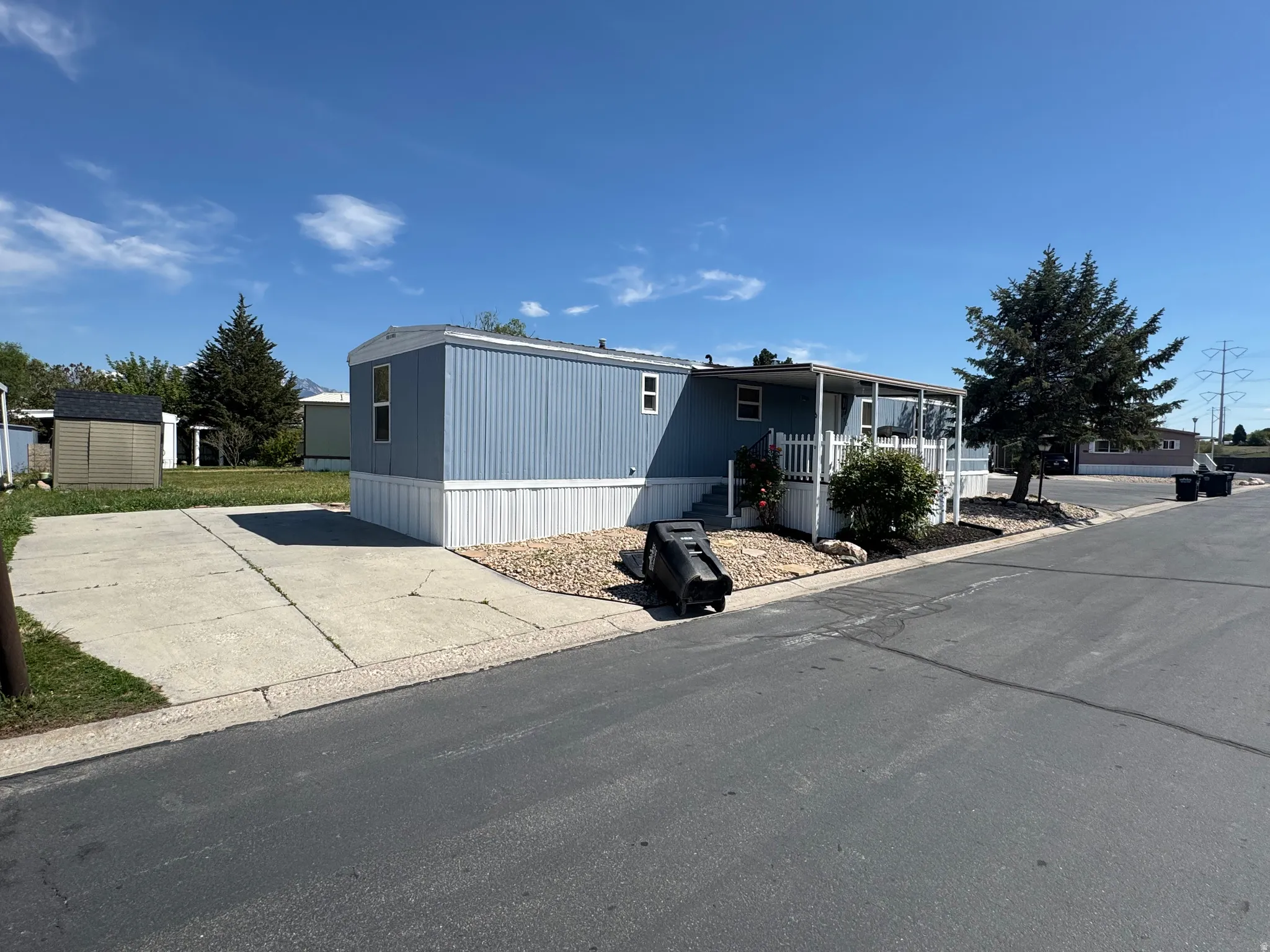 Blue manufactured home with white trim and a covered porch