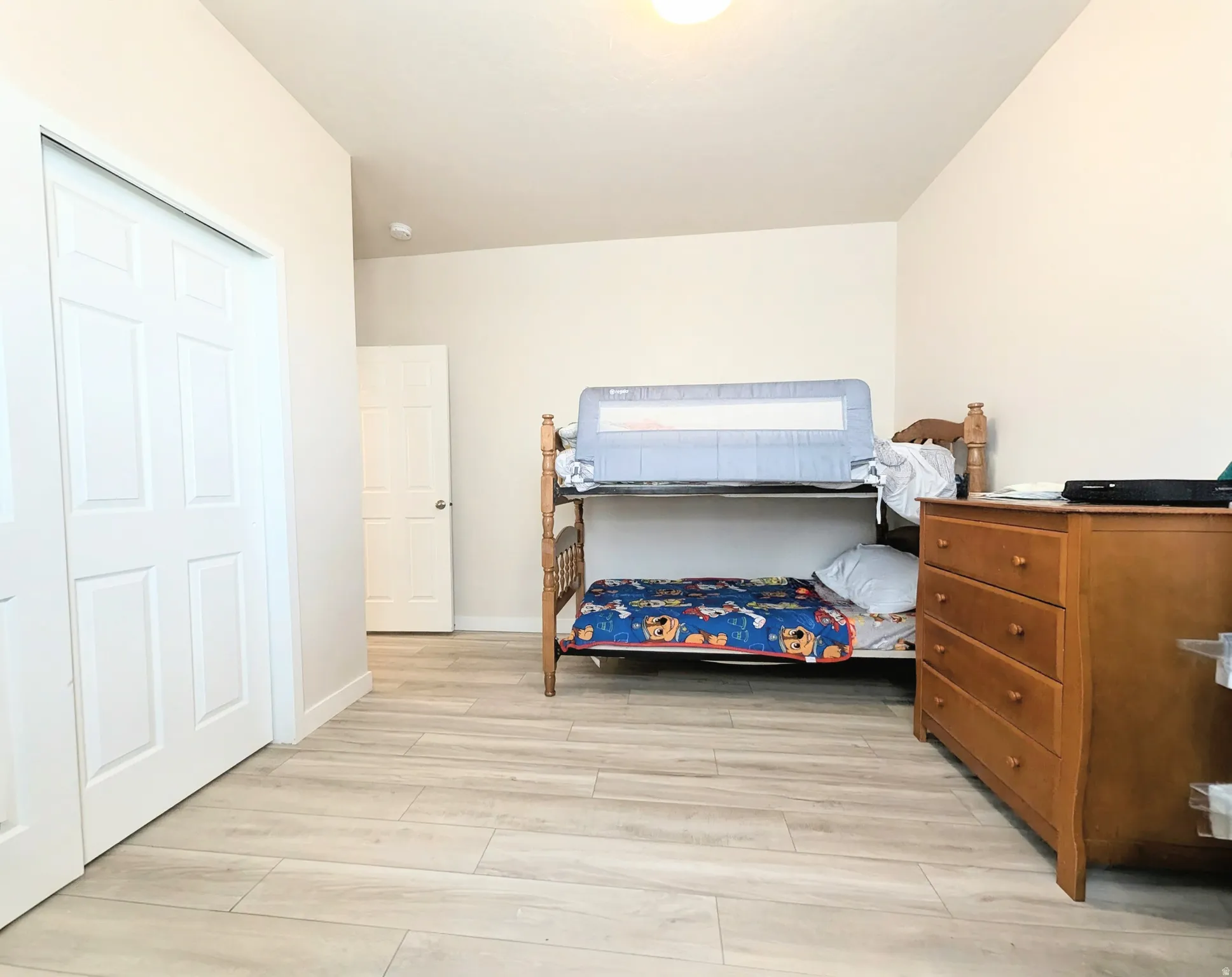 Interior room featuring light wood-finish flooring, white walls, and a white ceiling with a flush-mount light fixture