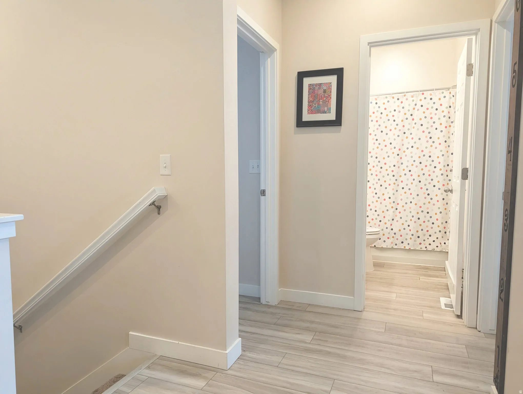 Hallway featuring light wood-finish flooring and neutral wall tones