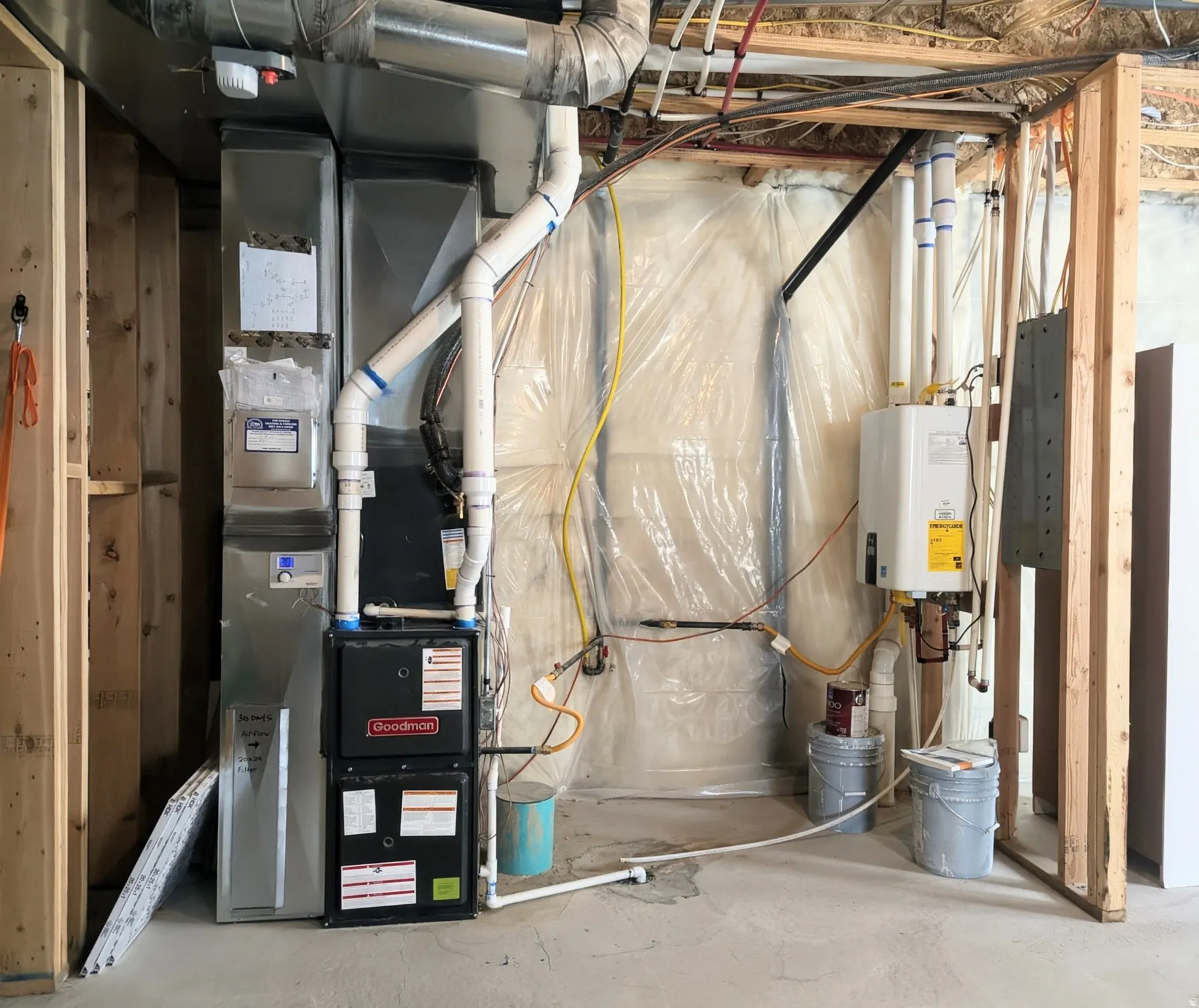 Goodman furnace, ductwork, and tankless water heater installation within a framed utility area