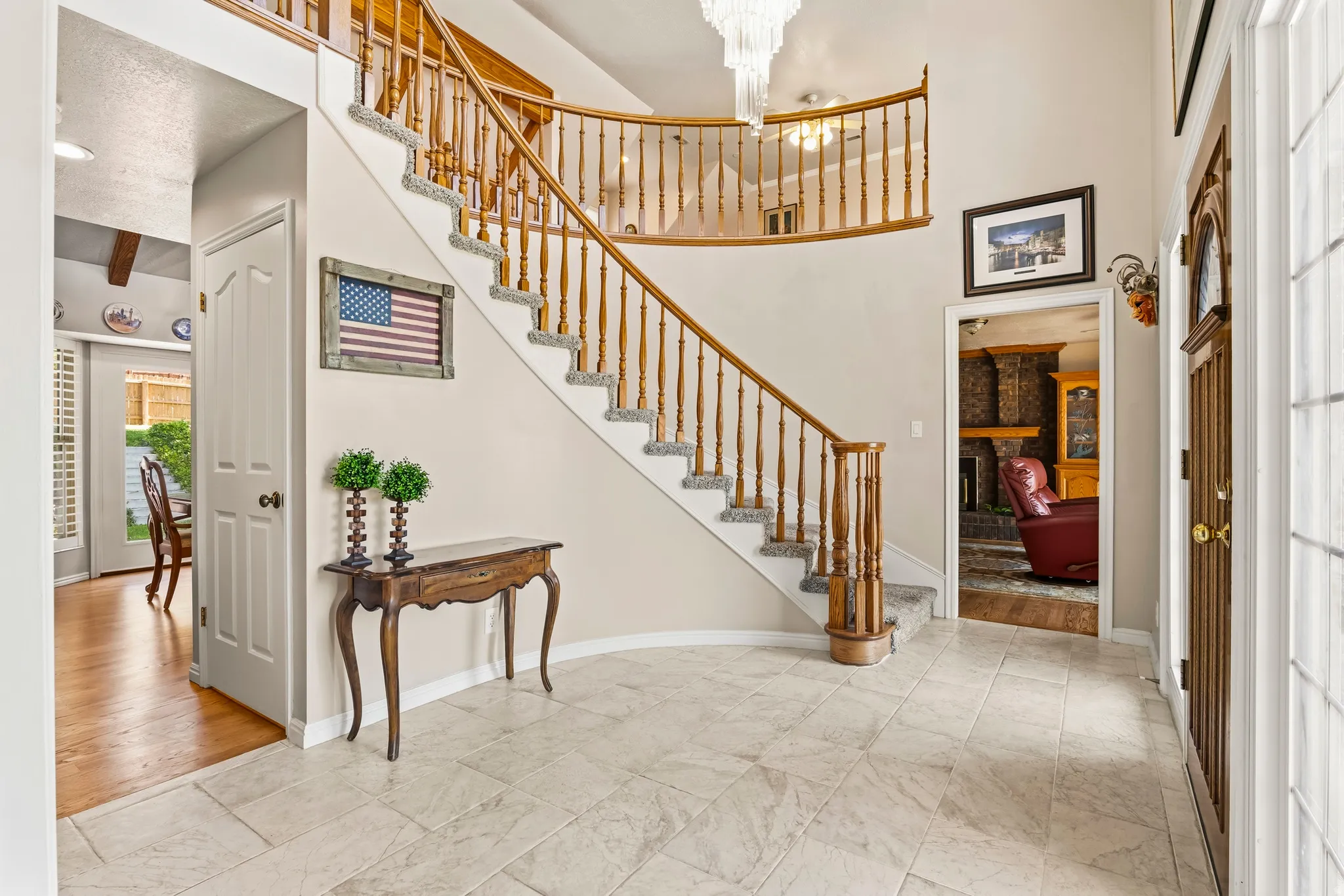 Grand entryway featuring a curved staircase with wood railings and carpeted treads