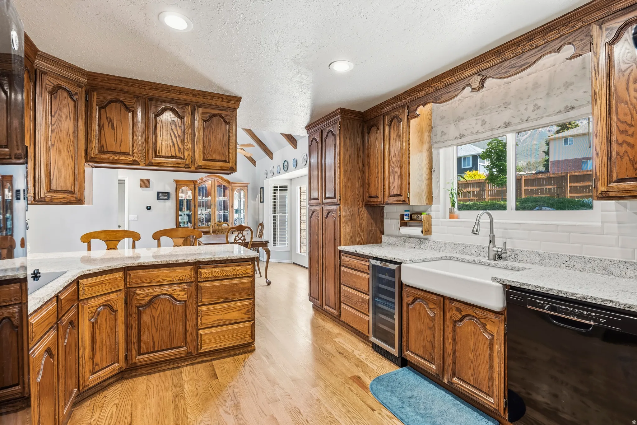 Kitchen featuring wood-finish cabinetry, light-toned countertops, and wood-finish flooring