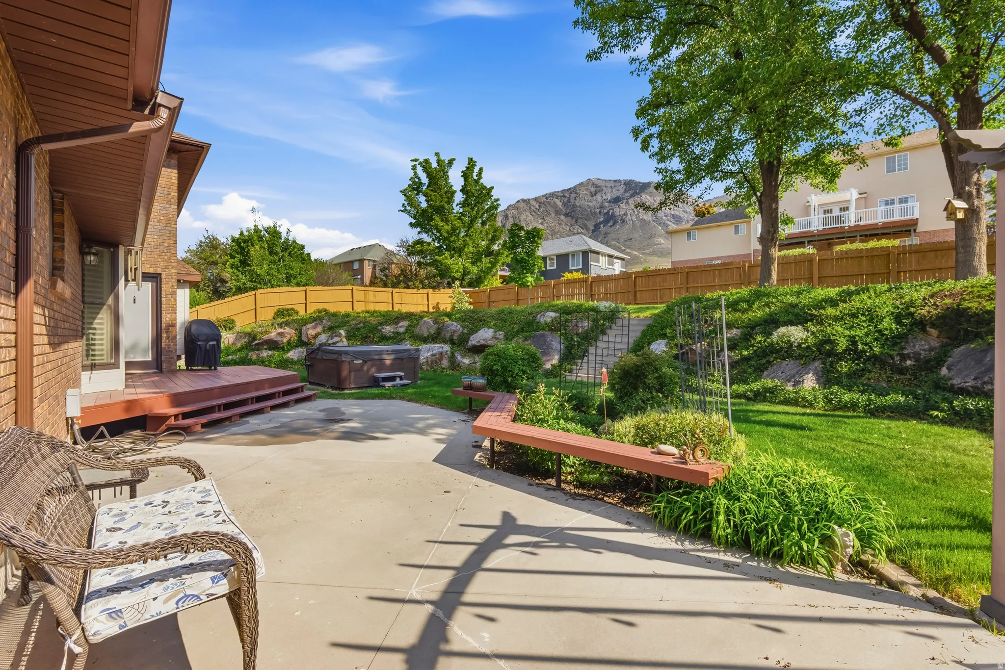 Expansive patio featuring a concrete surface and a tiered landscape