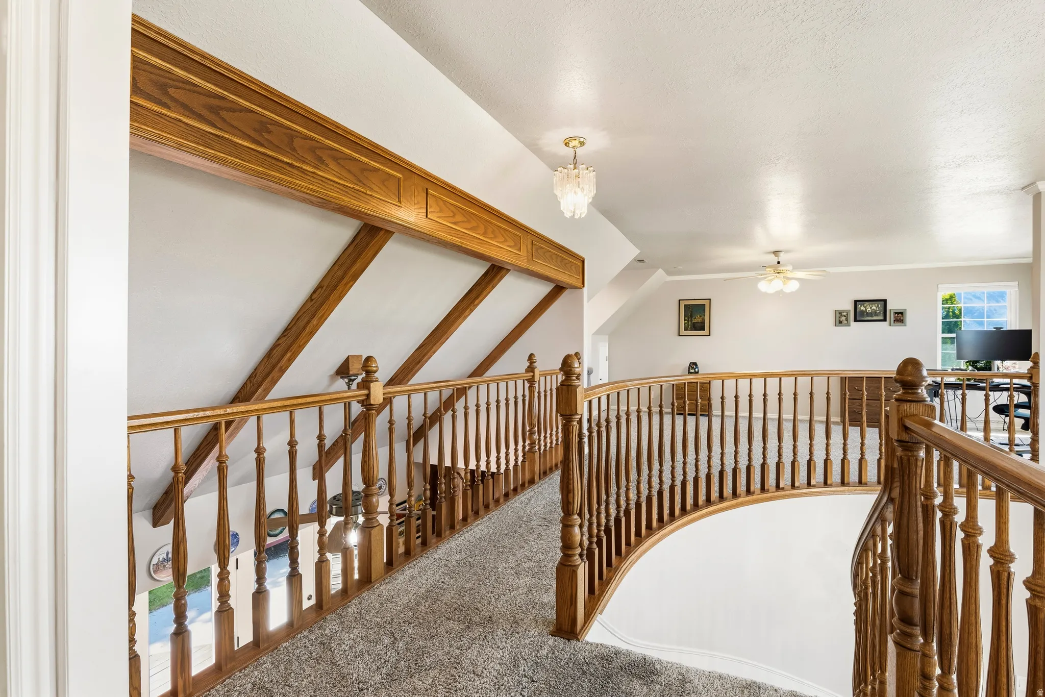 Upper level landing featuring light-toned carpeting and wood railings