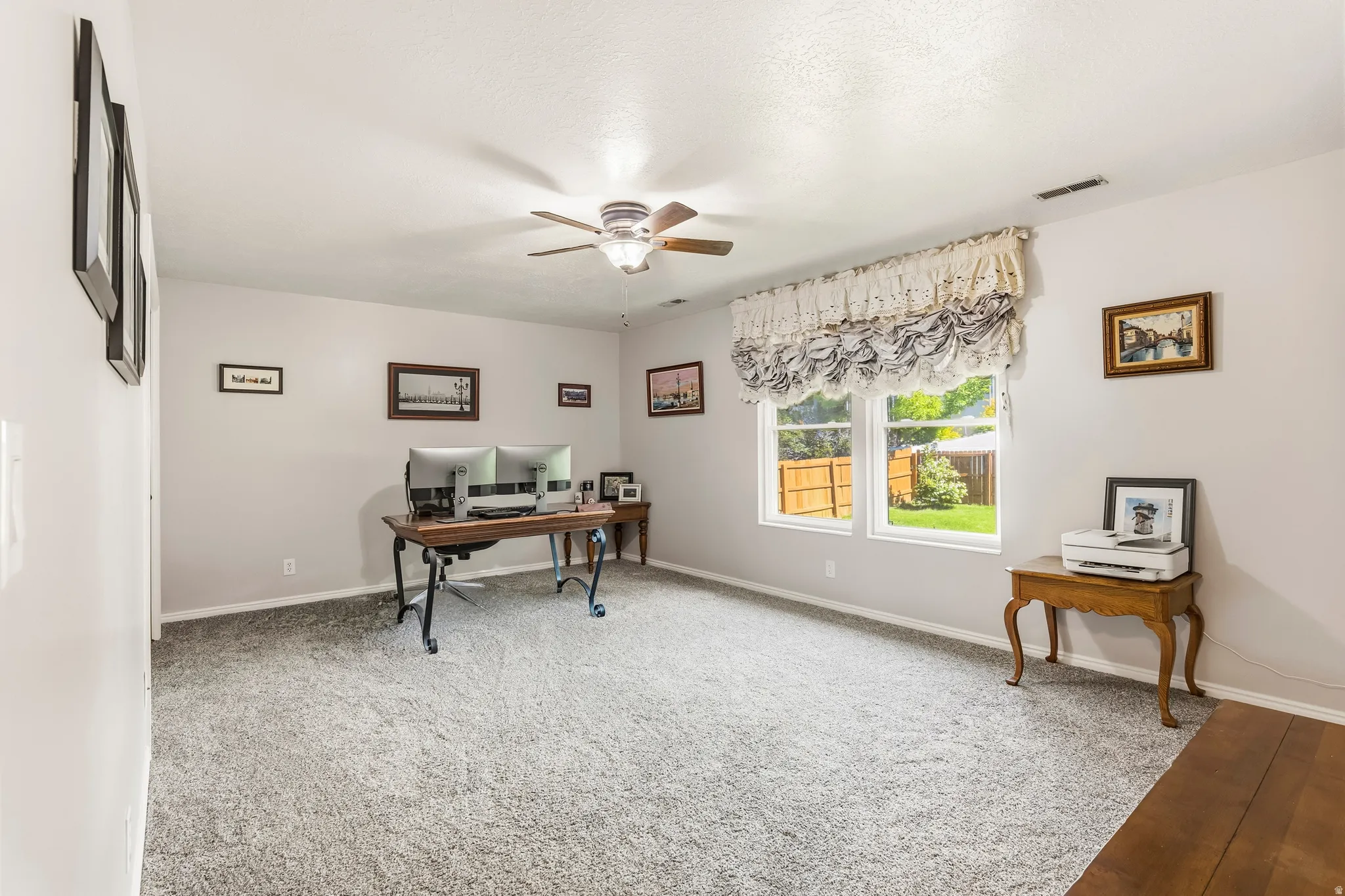 Spacious room with light gray wall paint and textured carpeting