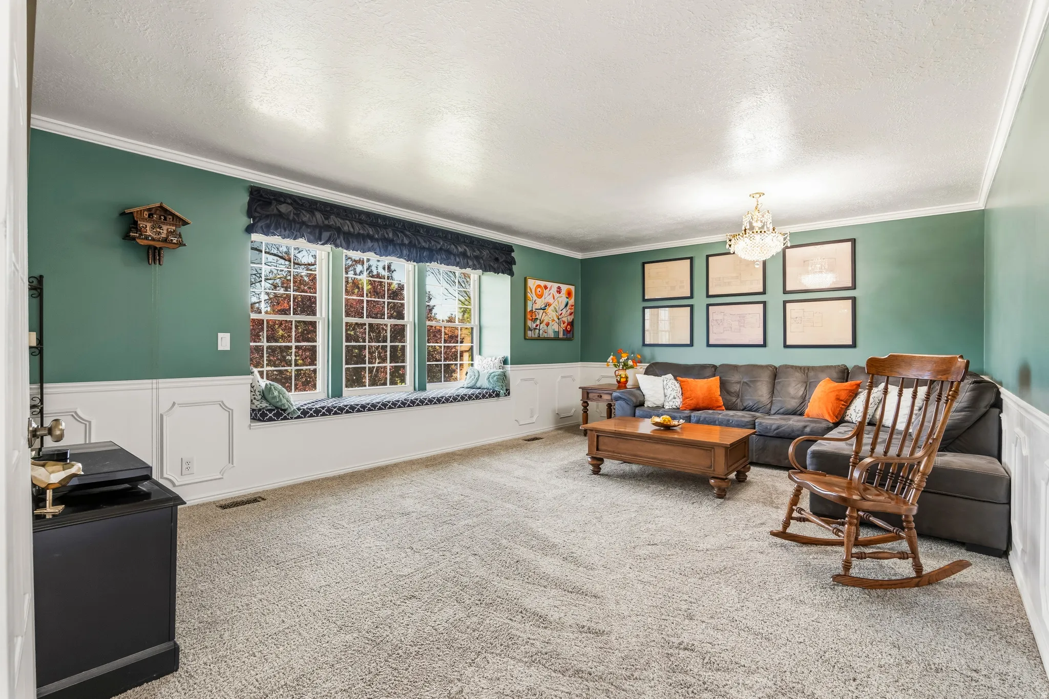Spacious common room featuring wainscoting, crown molding, and a built-in window seat