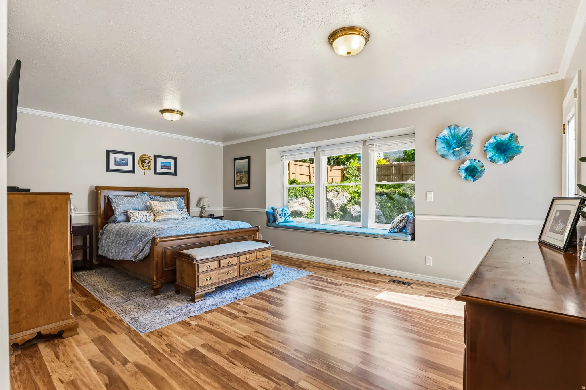 Spacious room featuring wood-finish flooring and a large bay window