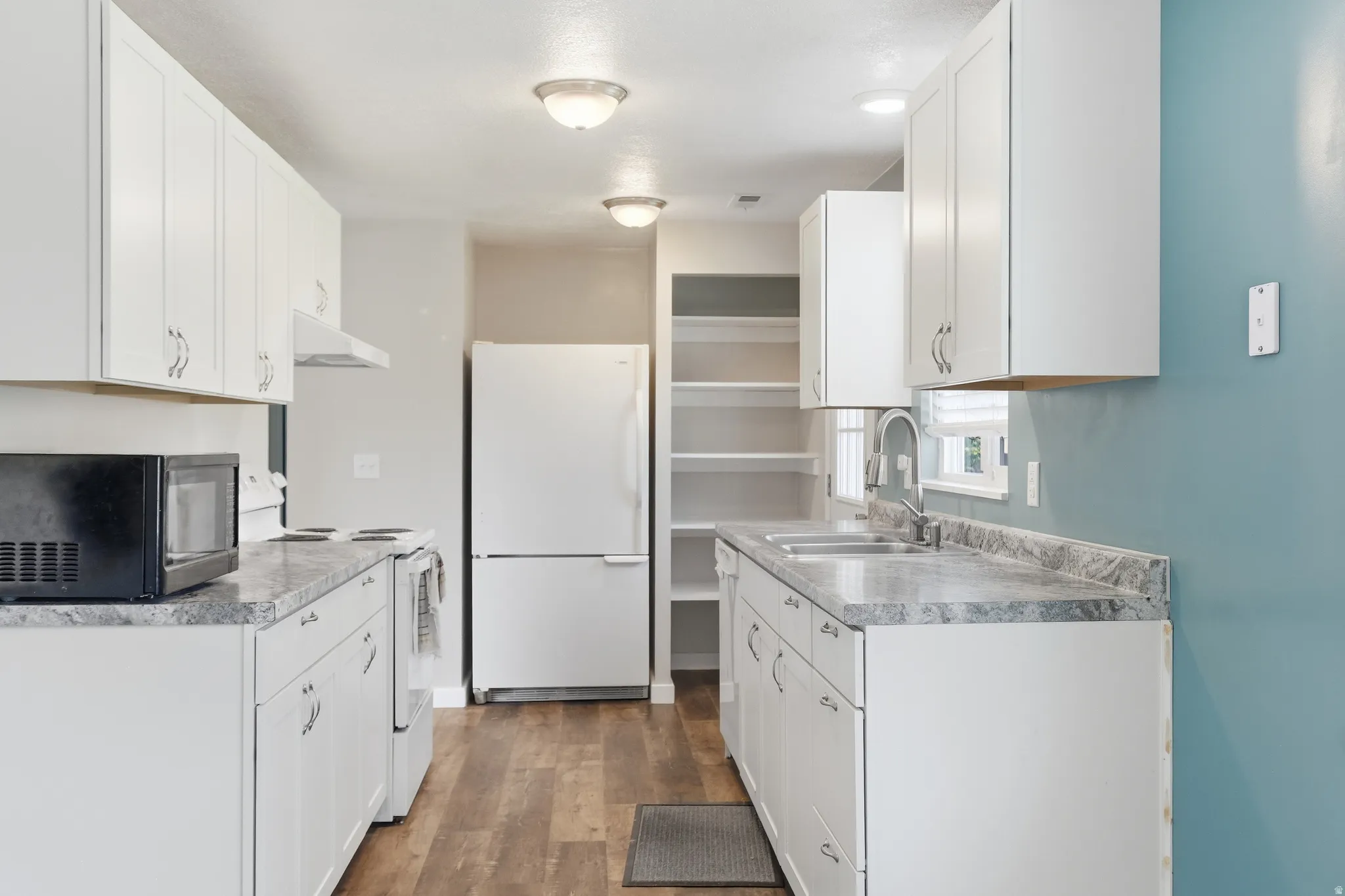 Kitchen featuring white cabinetry, gray countertops, wood-finish flooring, recessed lighting, and a double basin sink with a high-arc faucet