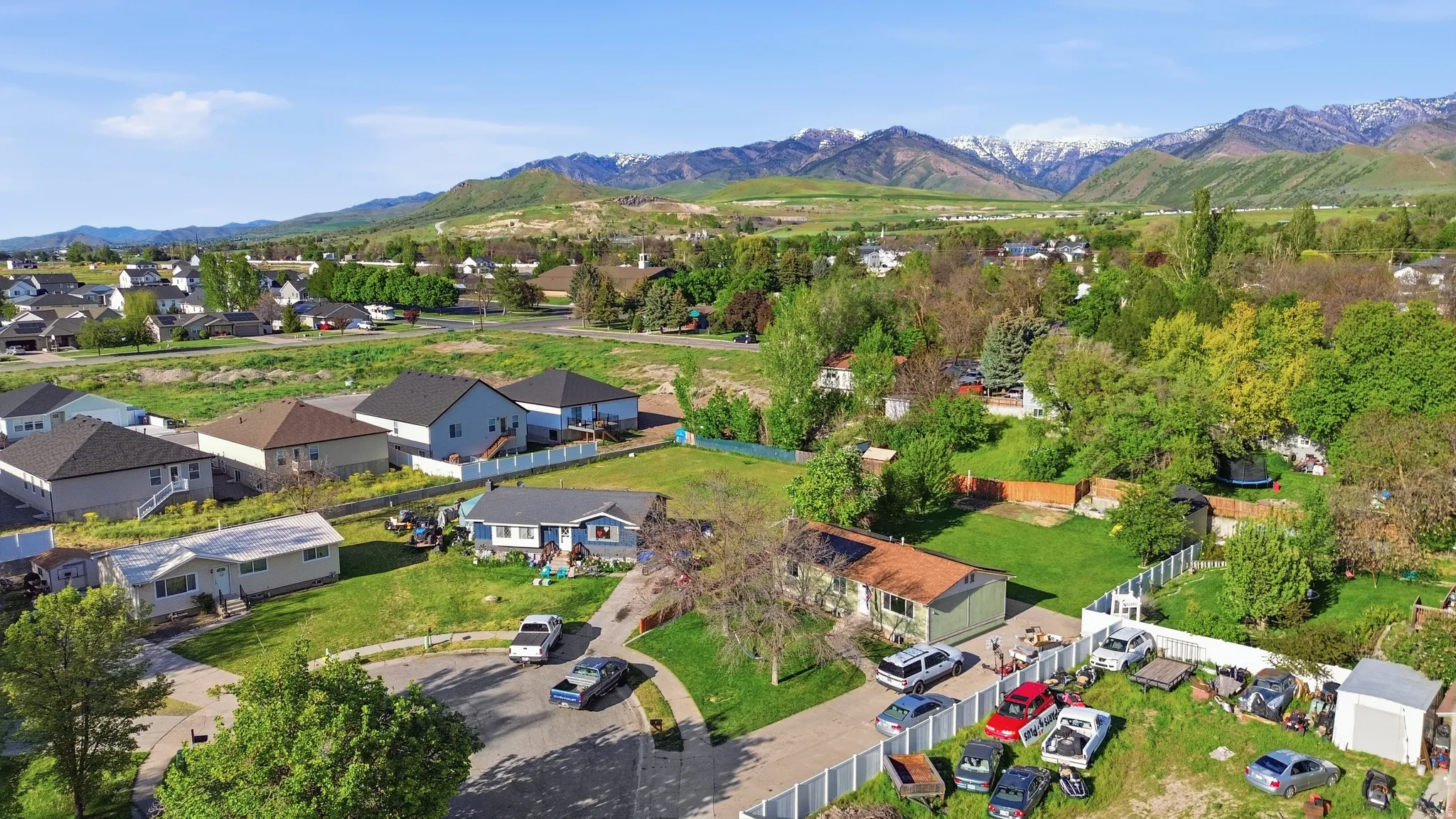Expansive residential area with diverse home styles, mature landscaping, and mountain backdrop