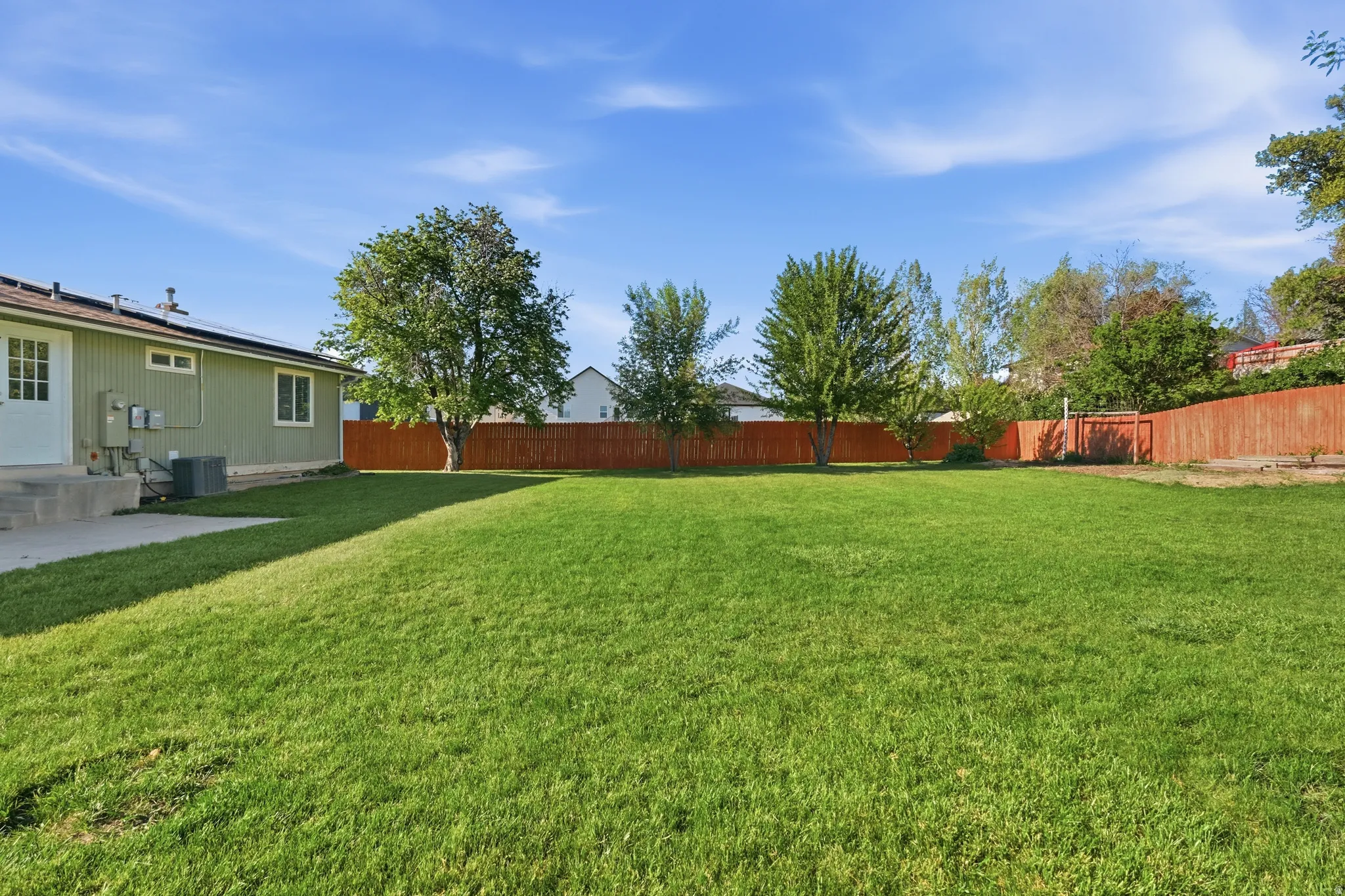 Expansive green lawn framed by a wood privacy fence