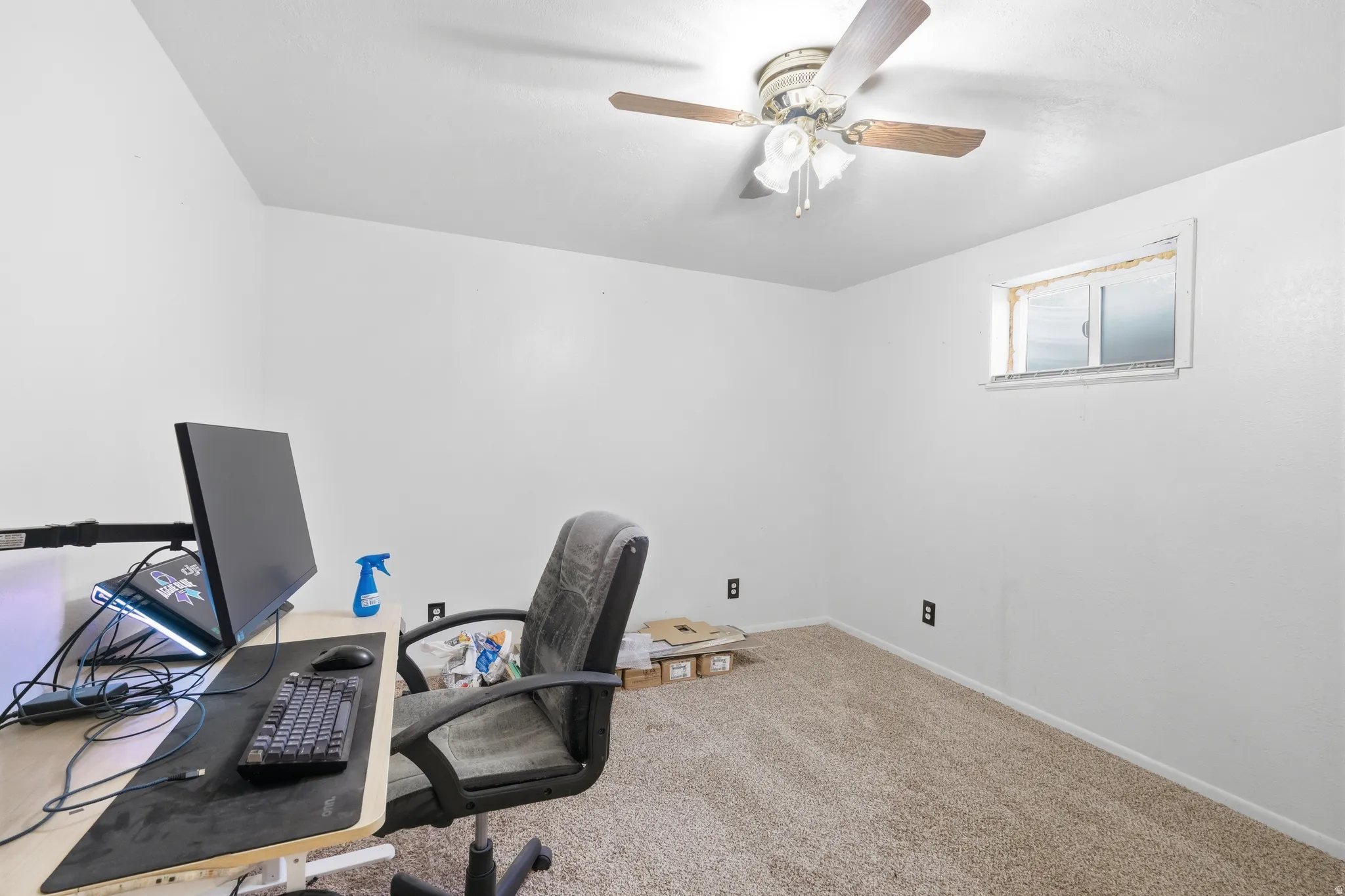 Carpeted room with a ceiling fan light fixture and a single casement window