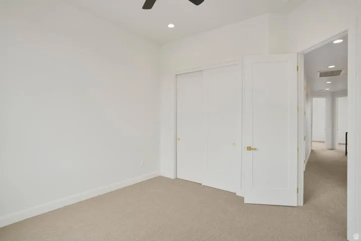 Carpeted interior space featuring white walls and baseboards