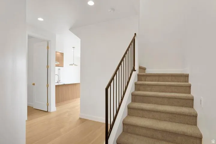 Carpeted staircase with an iron railing