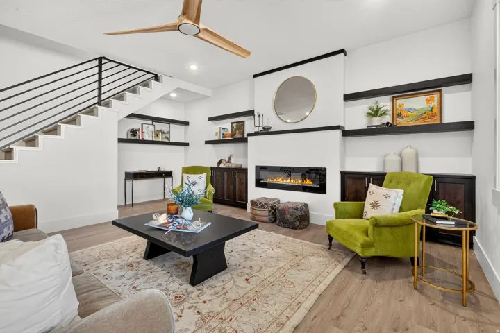 Living area featuring a sleek linear fireplace, wood-finish flooring, and a contemporary ceiling fan