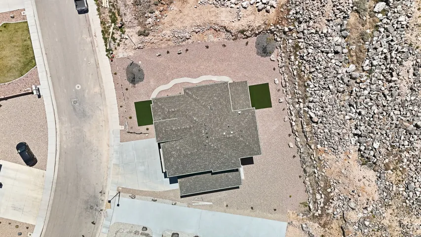 Contemporary roofline on a residence featuring a concrete driveway and xeriscaping