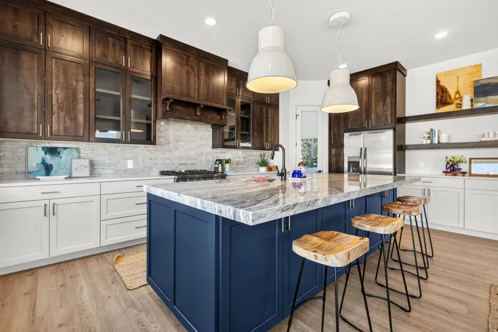 Kitchen with a large blue island featuring a stone countertop