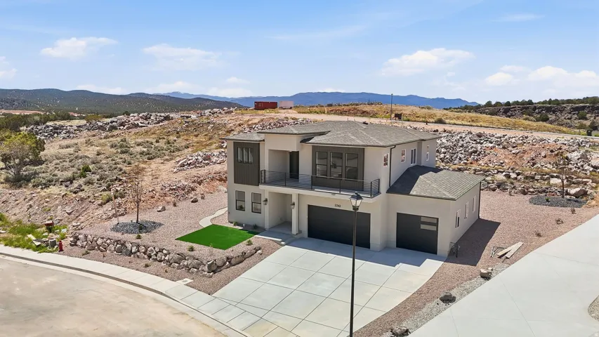 Contemporary two-story residence with a light-colored stucco exterior and dark trim accents