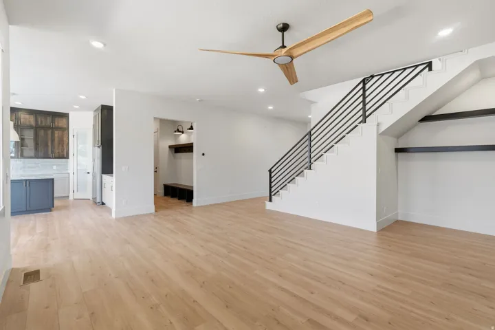 Open-concept living space featuring wood-finish flooring, a modern ceiling fan, and recessed lighting