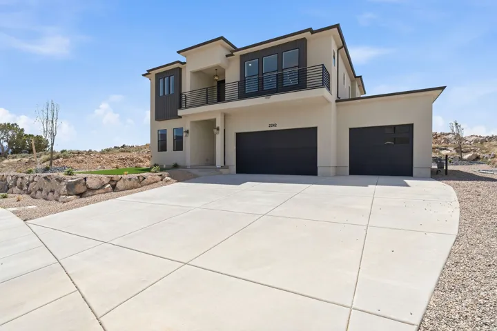 Contemporary two-story exterior featuring a smooth stucco finish with dark contrasting accents