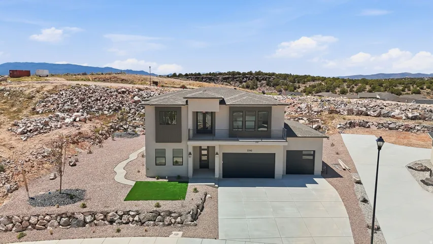 Modern two-story stucco exterior with a dark gray garage door