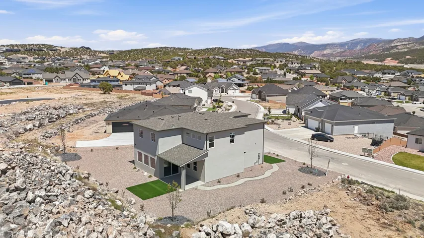 Modern two-story residence featuring a gray exterior, dark shingle roof, and multiple windows