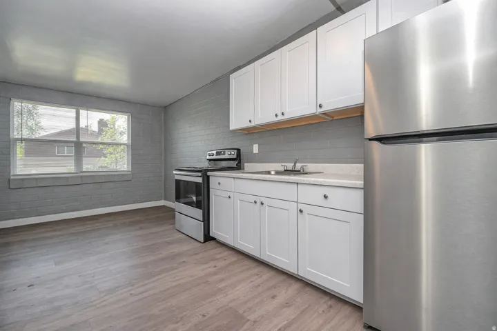 Kitchen featuring stainless steel appliances, light countertops, white cabinetry, and light wood-type flooring