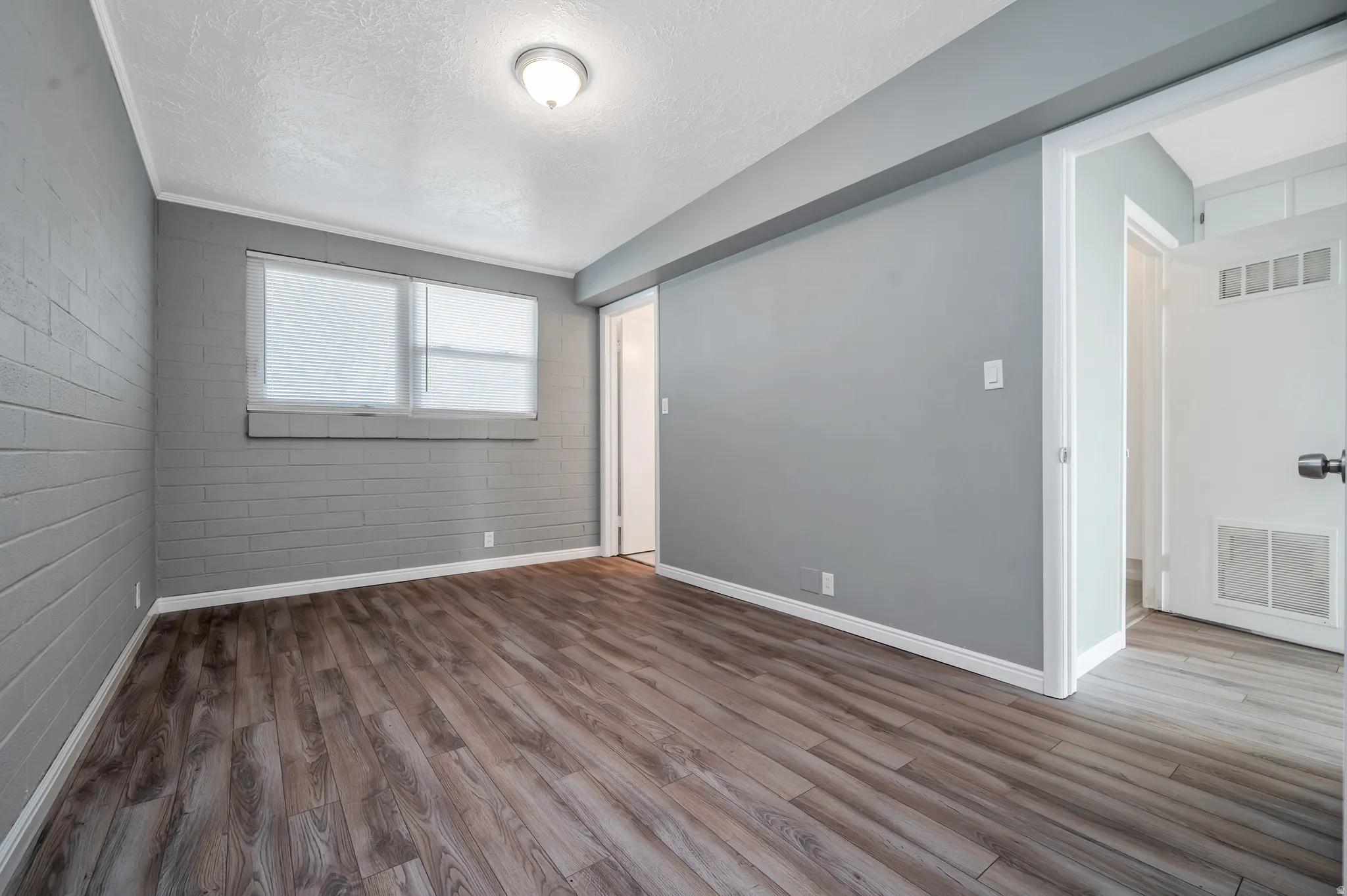 Spare room featuring dark wood-type flooring and a textured ceiling